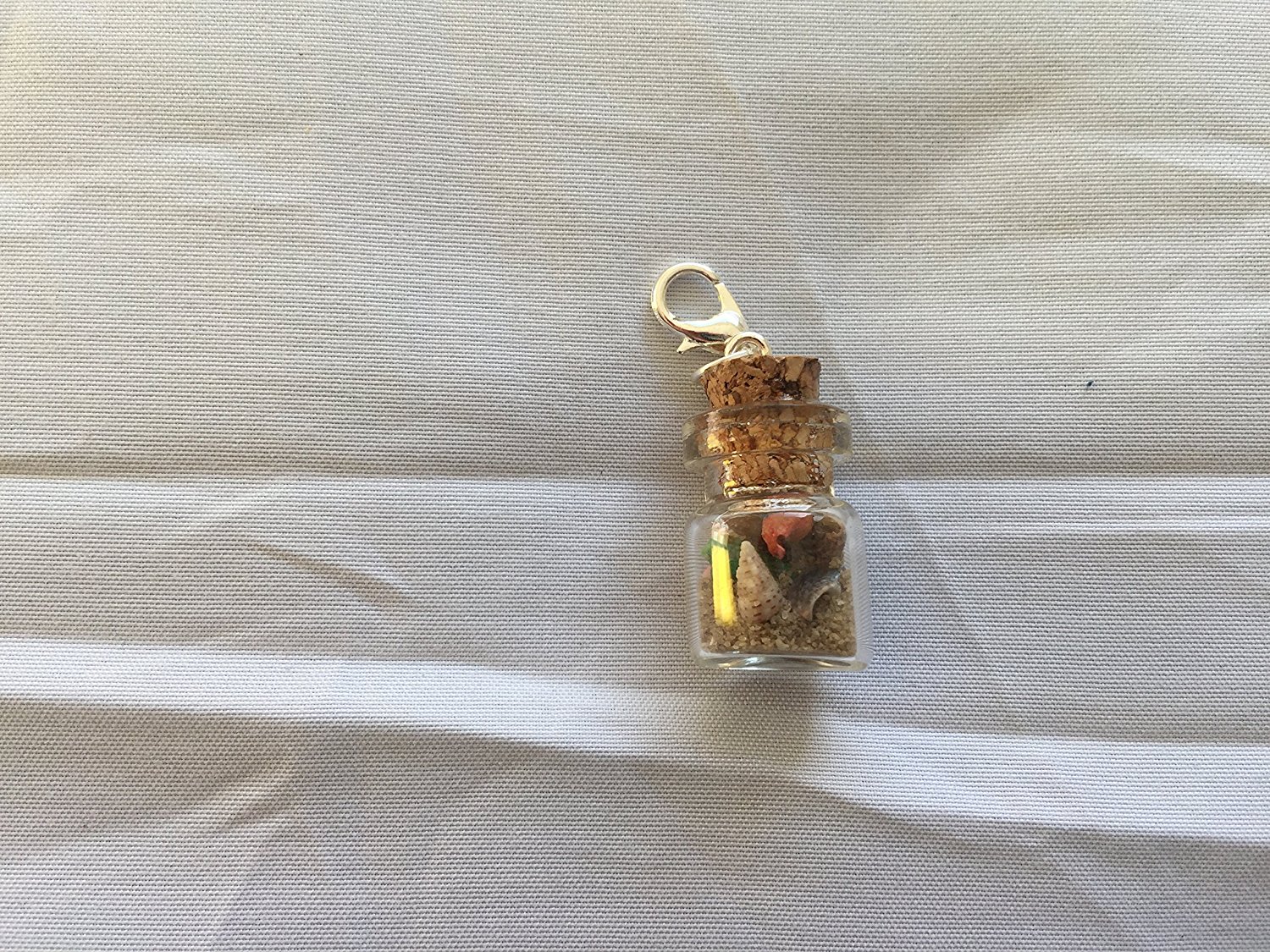 Mini glass jars filled with beach sand and tiny shells make great pendants. I have sold these at craft shows.