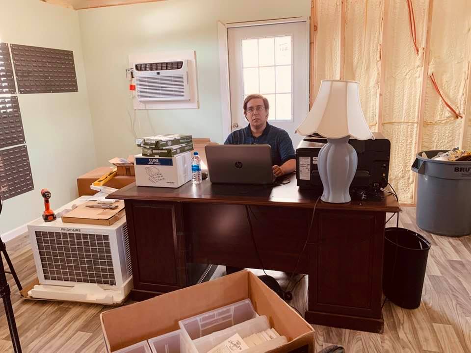 Brendon at my old desk in seed building in front of the wall the electrician ripped out yesterday.