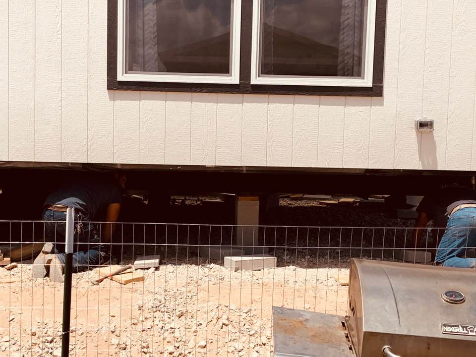 A closer look at the team leveling our new home on bricks. It took them three days to complete.