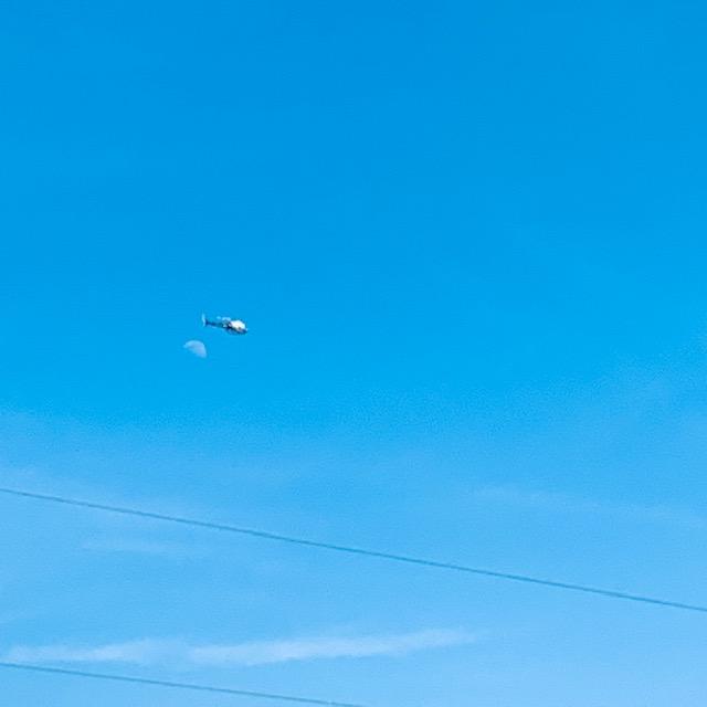 Police chopper flying right by the moon above our farm.