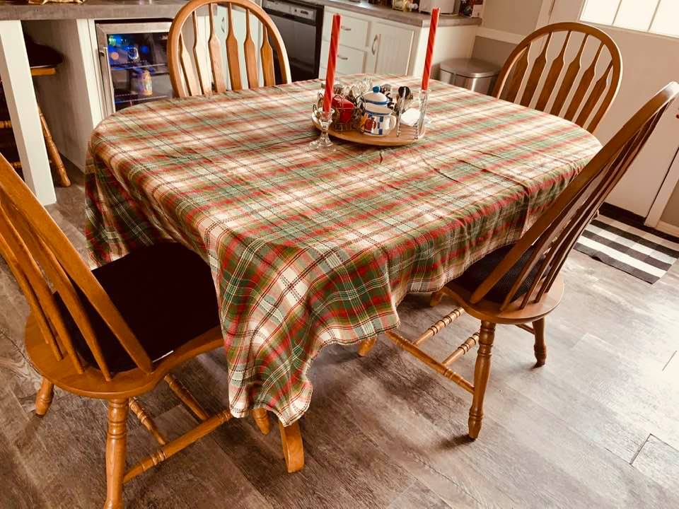 Even the kitchen table has Christmas decorations including a red and green plaid tablecloth.