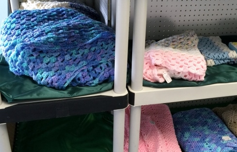 Ripple lap afghans I made on bottom shelf along with some granny square afghans.