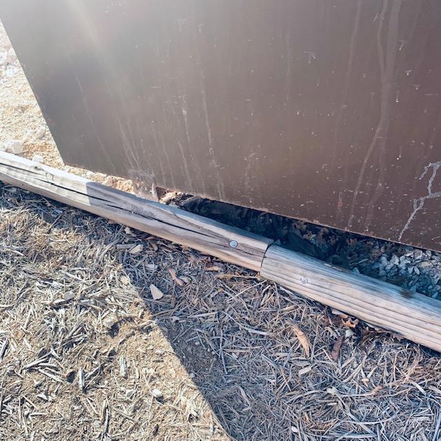 One tiny foot is on top of the timbers and the timbers were knocked out of the ground, spikes and all. What is with this guy? He lifted up the dumpster, why couldn't he set it back down in the same place?