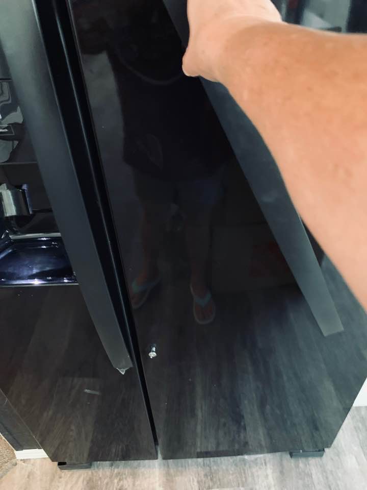 I am demonstrating my broken Whirlpool refrigerator handle, view #1. Mobile home repair is needed!