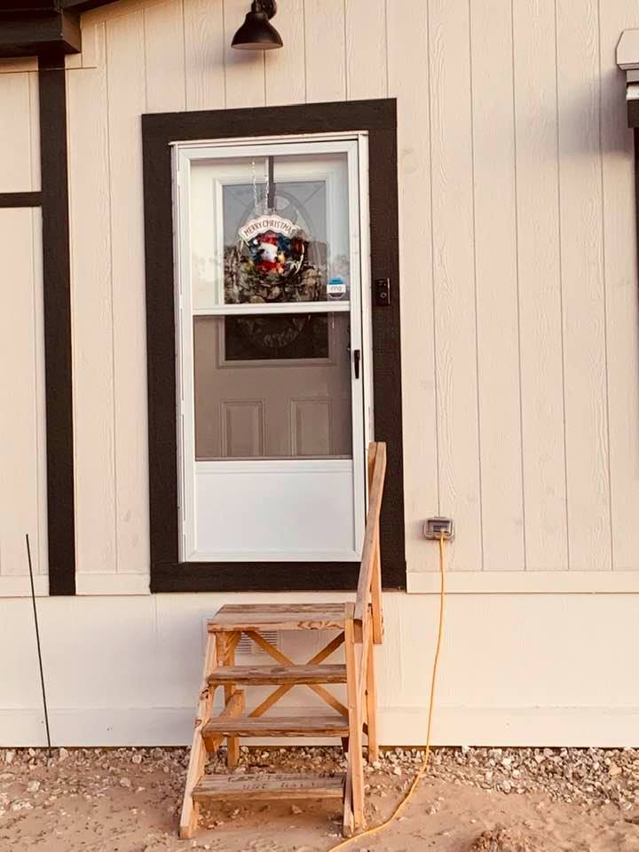Our front door with a Snoopy Christmas wreath and those ugly stairs that came with the house from Palm Harbor Homes. Hideous!