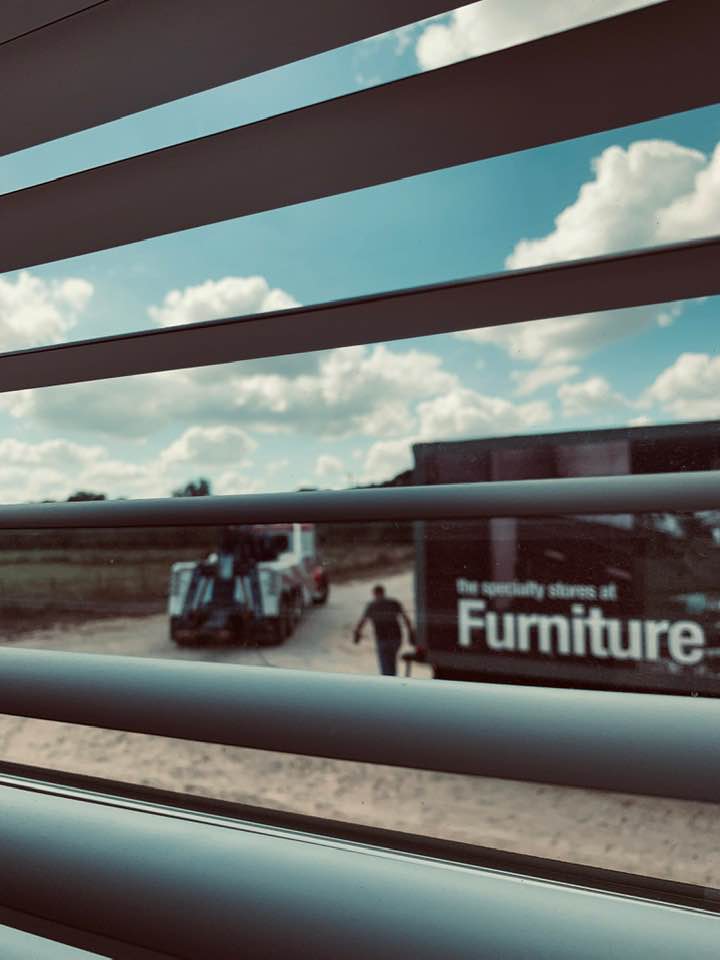 The tow truck finally arrived to help the furniture truck three hours after they called it in.