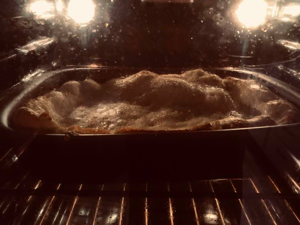 My fluffy German pancake through the oven door. These things are delicious and pretty easy to make.