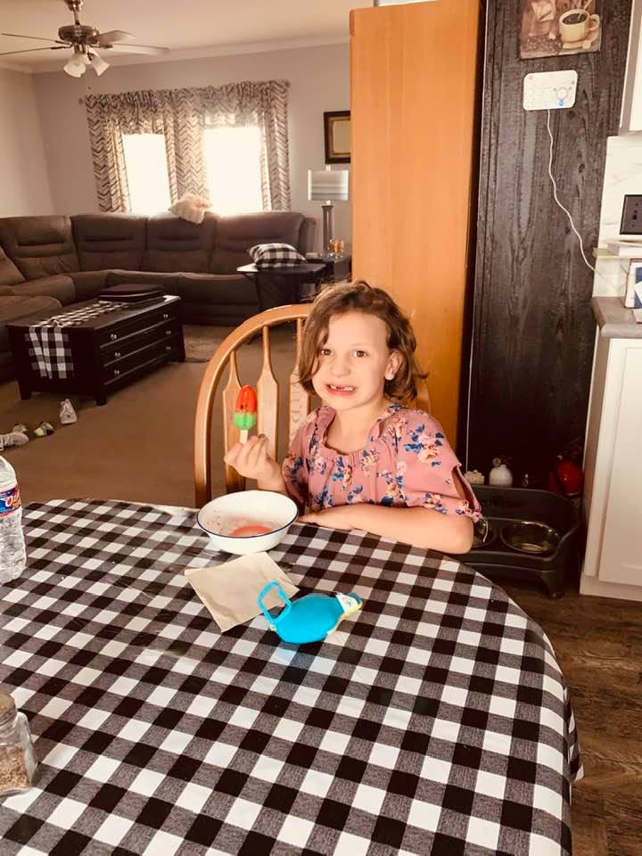 Holley is liking her watermelon Bomb Pop. Our living room is in the background.