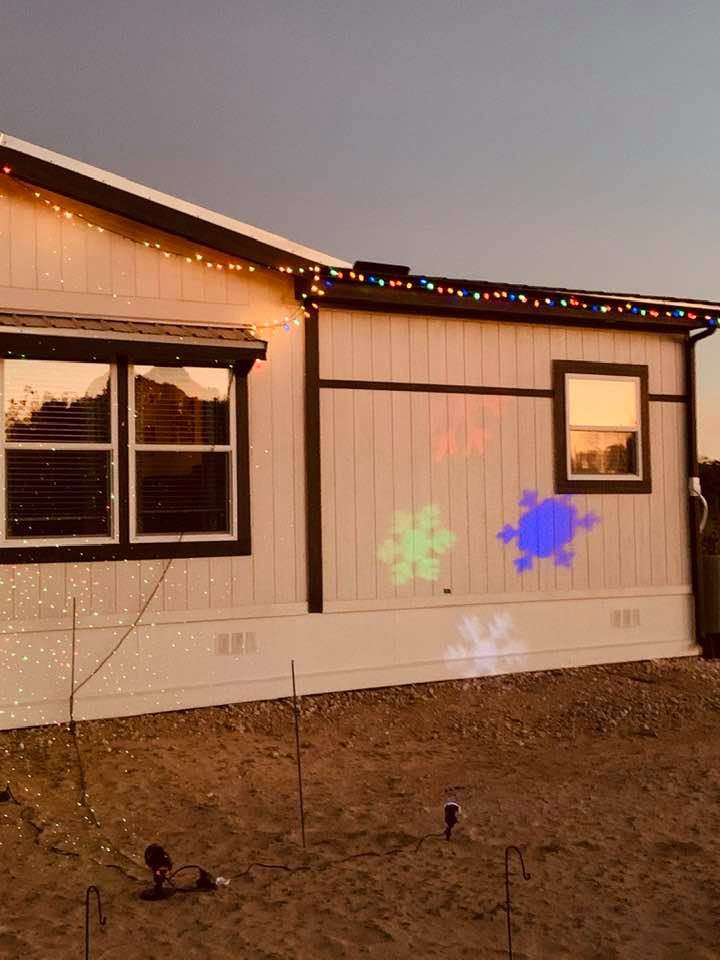 Projectors come on at dusk and shine red and green lights and snowflakes on our home.