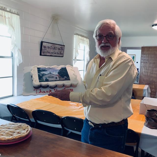 Pastor Jerry holding up the cupcake cake with the photo of the church in frosting. Yes, it was edible and so good!