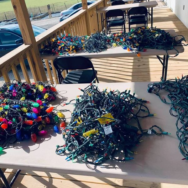 Piles of Christmas lights are being tested and then hung, even though it is not quite the season!