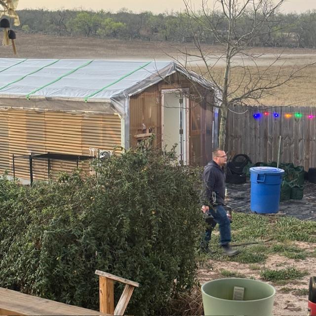 Matt in front of my greenhouse with the bands of fog in the field.