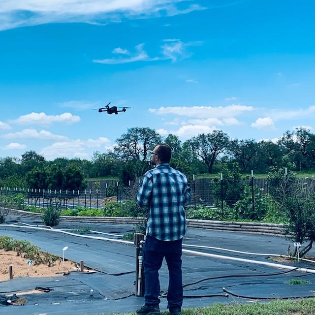 Matthew flying a drone in warmer weather back in the orchard.