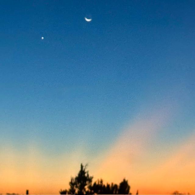 The sun is coming up as Venus, to the left of the moon, says goodbye.
