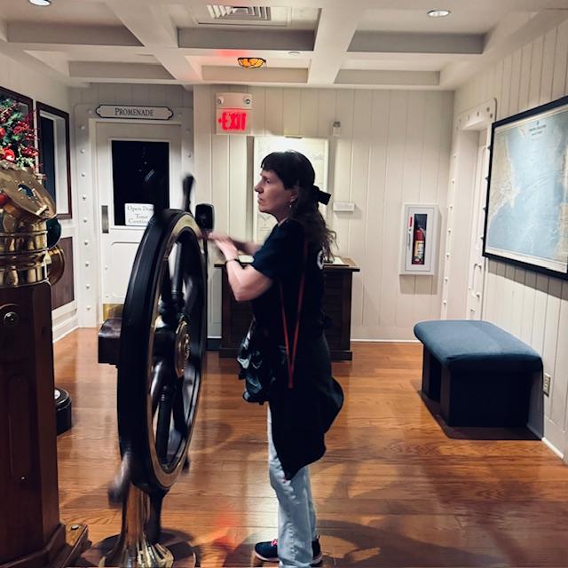 Norma on the bridge giving the ship's wheel a spin.