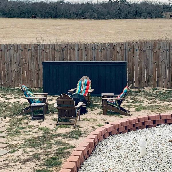 The new bar is behind the fire pit. You can see our new party lights on the fence behind the bar.