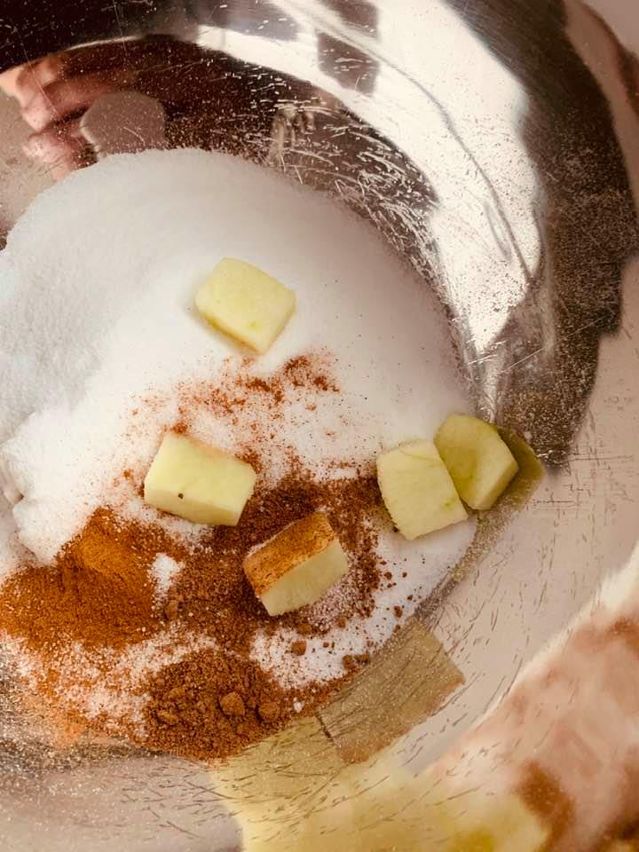 I put a few of the cut up apples into the sugar mix for the photo. Dump all six cups in and coat the apple pieces with the sugar mixture.