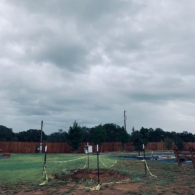 Site of our new pond. See our pine trees by the fence and look at those menacing skies. We really need the rain!