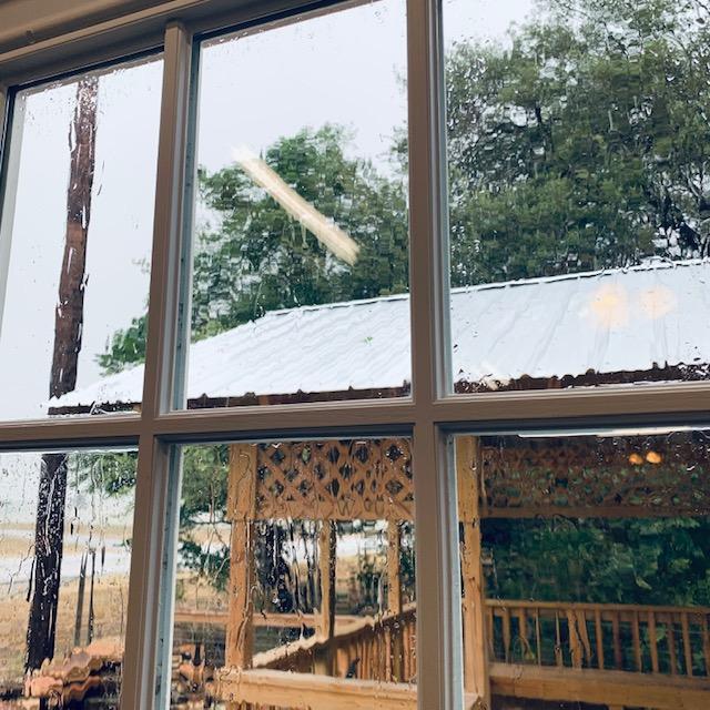 Looking out the farm store side window toward the gazebo and grass farm, it is pouring.