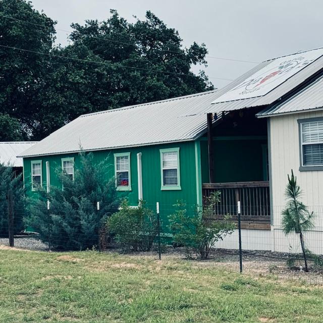 As you drive up on 2504, this is the side of our Farm Store that you will see. Yes, it is green. Come in the gate and you will see the front with stairs, ramp, and door.
