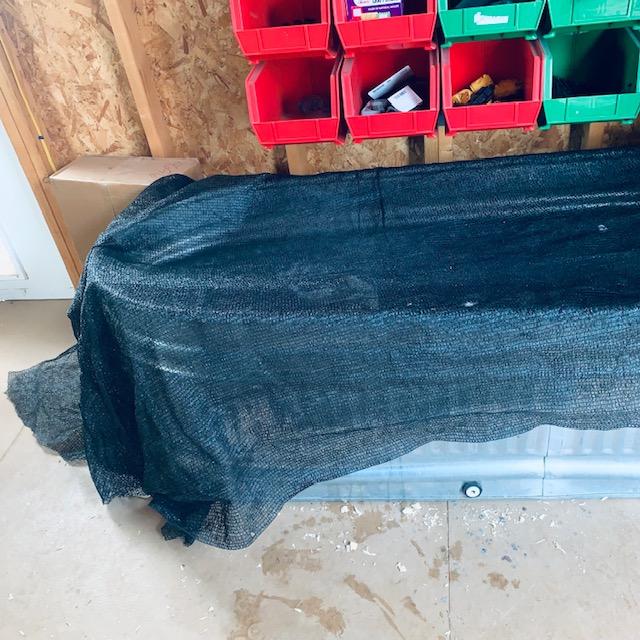 The shade cloth is a netting to keep the chicks safe inside the brooder instead of flying all over the shed and possibly getting hurt.