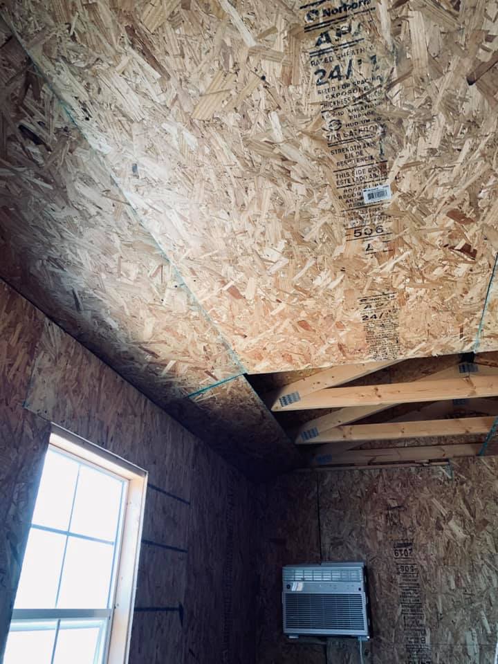 A contractor is putting up walls and a ceiling to help insulate the shed. With temps of at least 100 degrees Fahrenheit, the A/C unit running on a generator is not doing much.
