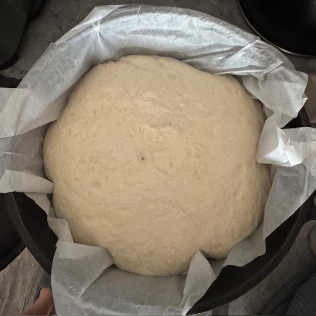 Here is the risen sourdough on parchment paper in the Dutch oven.