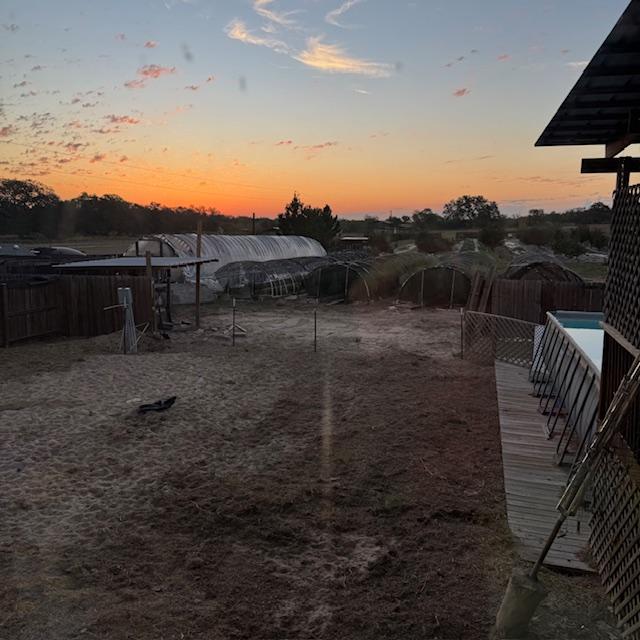 This sunrise photo shows the fence put across the big hole in the yard from three sheds being pulled out.