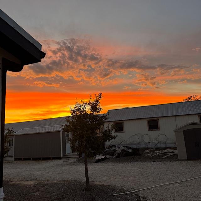 Sunset from the side porch with a lot of junk from taking apart sheds in front...
