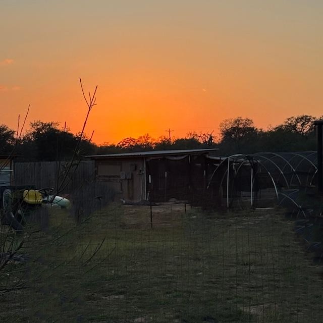 The sun is going down over the chicken coop.
