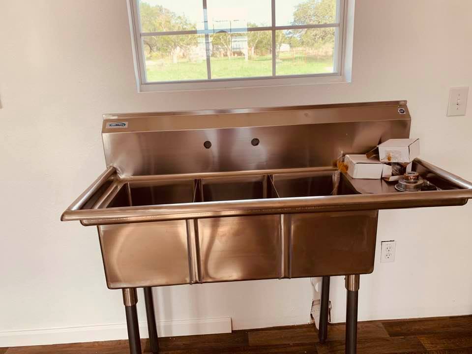 A 3 compartment commercial sink that is way too small for our needs. The plumber needs to order us a large sink so we can fit pots and pans in to clean them.