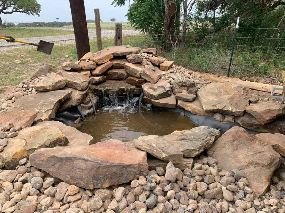In April of 2021, adding some finishing rocks to the pond. Take a good look at all of this page to tour our farm in photos.