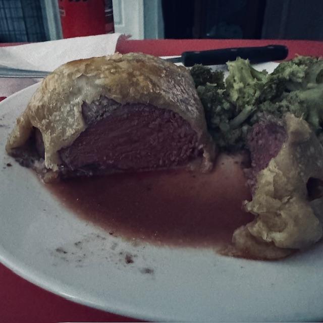 Cut wellington on my plate. The red liquid is the wine sauce. It was so good.